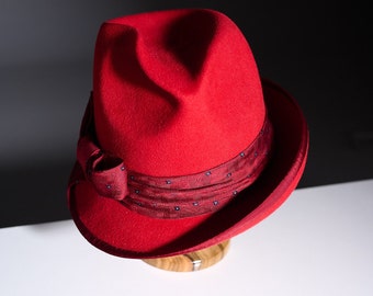 A hat for fashionistas. A felt red unique hat . One of a kind fedora hat with silk bow. Handcrafted wool asymmetrical trilby fedora hat