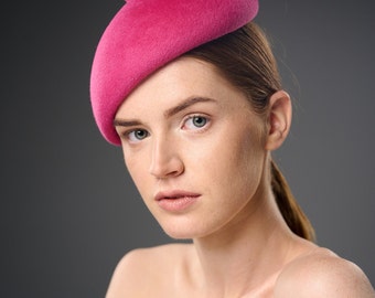 A pink Barbie-style beret. Bright pink fuchsia stylish minimalist beret for a girl. Oversize wool beret for women