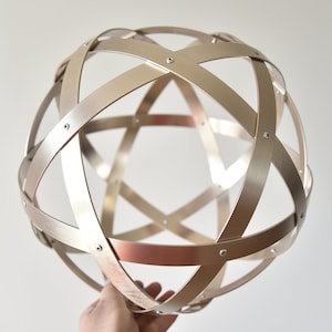 Pentasphere in copper-plated aluminum with brushed effect, 32 cm in diameter, 2 cm wide bands. Symmetrical Weaves!