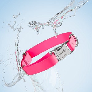 Puede incluir: Un collar para perro rosa brillante con una hebilla plateada y el nombre "Candy" grabado. El collar est&aacute; hecho de un material impermeable. Salpicaduras de agua alrededor del collar sobre un fondo azul claro.