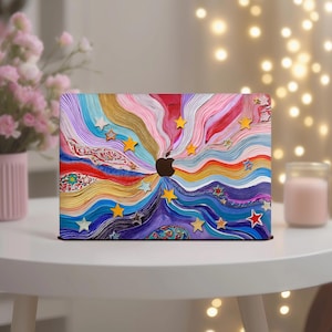 Puede incluir: Una funda para portátil con un diseño abstracto y colorido. La funda presenta un patrón arremolinado de colores del arcoíris, incluyendo azul, morado, amarillo y rojo. Estrellas doradas y amarillas están dispersas por el diseño. El logotipo de Apple es visible en el centro.
