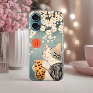 May include: A phone case with a cute cartoon cat drinking boba tea. The background is a blue and white floral pattern with a red circle that says "香氣" in Japanese.