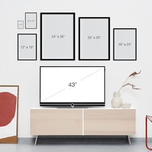 May include: A white wall with a 43-inch television on a light wood entertainment center. The television is surrounded by black picture frames with various sizes and dimensions, including 8x12 inches, 12x18 inches, 16x24 inches, 20x30 inches, and 24x36 inches. The frames are arranged in a symmetrical pattern.