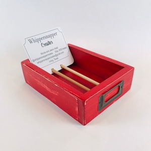 May include: Red wooden box with a brass handle and three wooden dividers. The box has a white card inside with the text "Whippersnapper Creates" and contact information for the business.