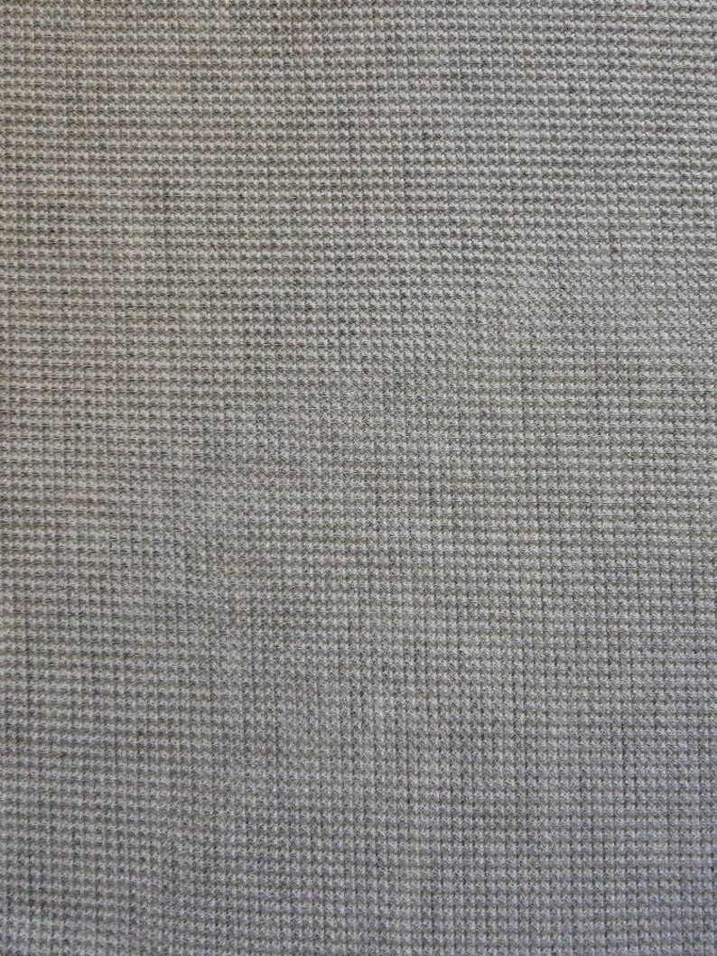 May include: A close-up of a gray textured fabric with a waffle weave pattern.