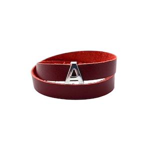 May include: A burgundy leather wrap bracelet with a silver letter A charm.