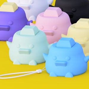 May include: A set of nine colourful toy ducks with different coloured lids. The ducks are made of plastic and have a smooth, rounded surface. The ducks are arranged in a row on a yellow surface.