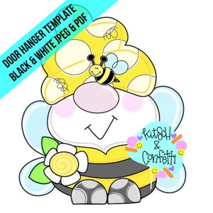 May include: A yellow and black bee door hanger with a flower and a bee on top. The bee has a pink nose and black eyes. The door hanger has the text "kitsch & confetti" on it.