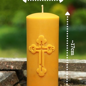 May include: A yellow beeswax candle with a cross design, measuring approximately 6 inches in diameter and 17 inches in height.