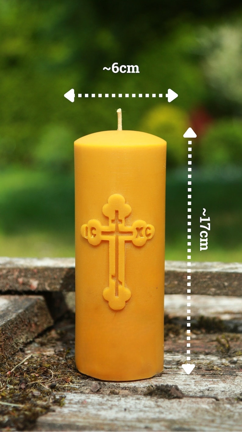 May include: A yellow beeswax candle with a cross design, measuring approximately 6 inches in diameter and 17 inches in height.
