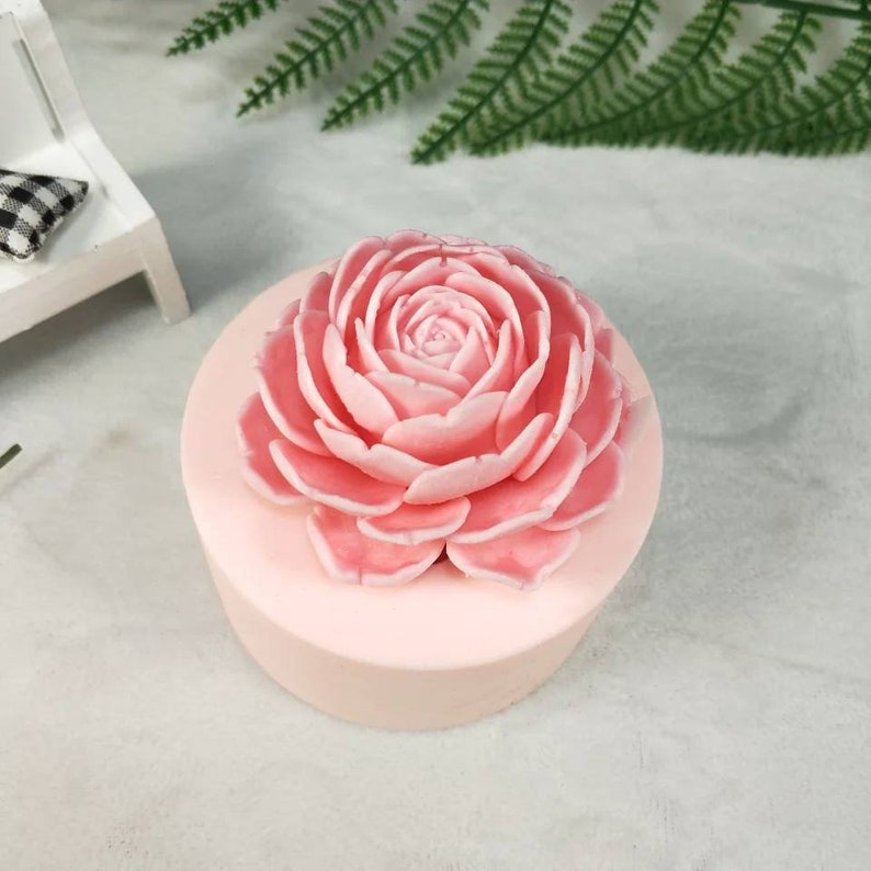 May include: A pink silicone mold shaped like a large rose flower. The mold is perfect for making soap, candles, or other crafts.