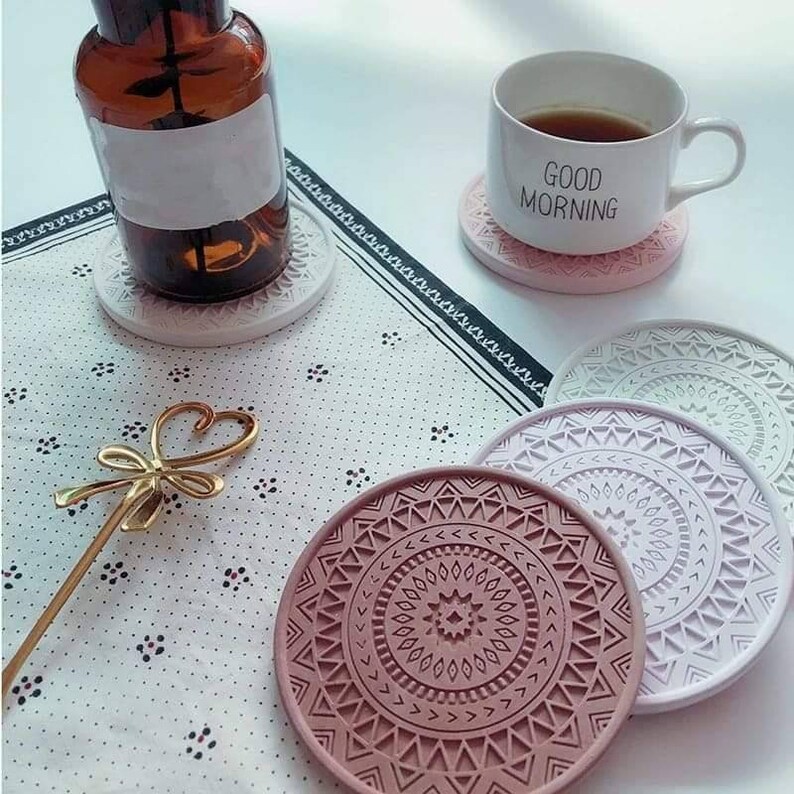 May include: Set of six colourful coasters with geometric patterns. The coasters are made from a durable material and feature a variety of colours, including pink, purple, and green. The coasters are ideal for protecting your furniture from heat and spills.