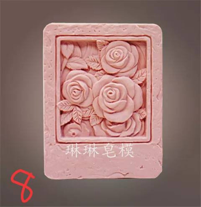 May include: Pink silicone mold with a raised design of roses and leaves. The mold has a rectangular shape and a raised border. The text "remarkable" is printed in white on the mold.