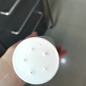 Puede incluir: Base de pl&aacute;stico blanca con seis peque&ntilde;os agujeros, probablemente para una maceta o una maceta de flores.