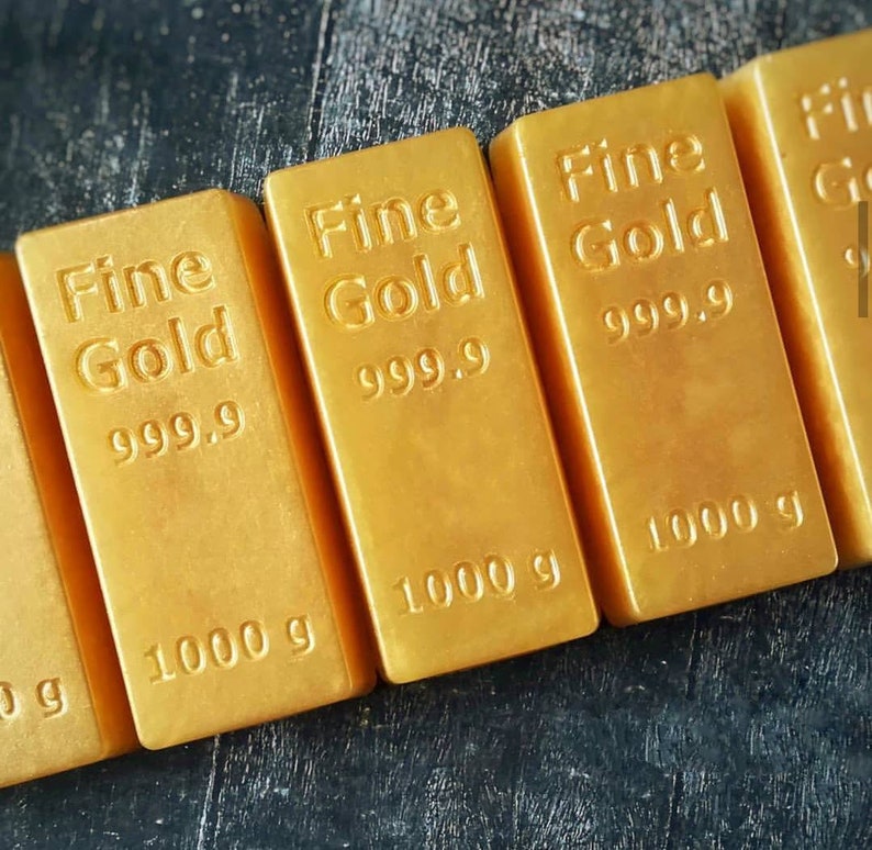 Może przedstawiać: Cztery sztabki złota z nadrukiem "Fine Gold 999.9" i "1000 g".