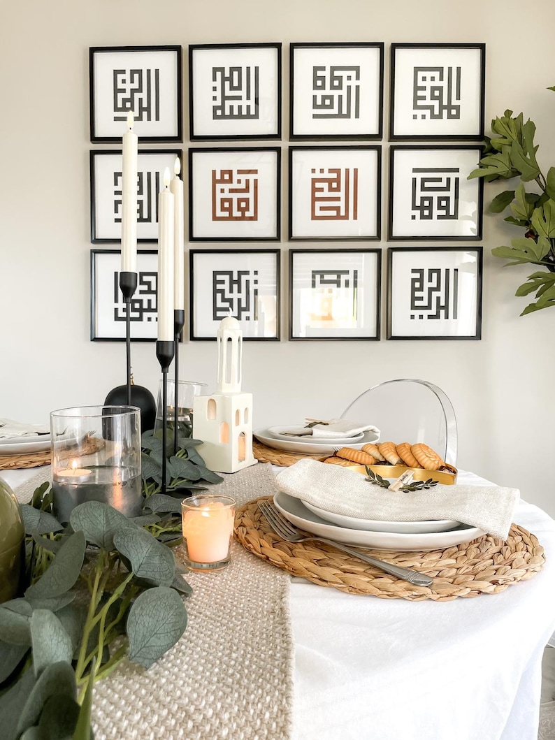 Puede incluir: Un mantel blanco con un camino de mesa beige y un mantel individual tejido. Un plato blanco con una servilleta blanca y un tenedor dorado est&aacute; sobre el mantel individual. Hay velas y vegetaci&oacute;n en la mesa. Un portavelas de cer&aacute;mica blanca con forma de casa est&aacute; sobre la mesa. Hay 12 impresiones enmarcadas en blanco y negro en la pared detr&aacute;s de la mesa.
