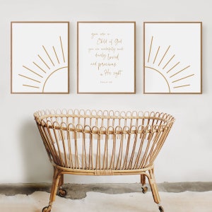 Op de afbeelding: Drie ingelijste prints met een minimalistisch zonontwerp en een citaat uit Psalm 139: "Je bent een kind van God. Je bent wonderbaarlijk gemaakt, innig geliefd en kostbaar in zijn ogen."