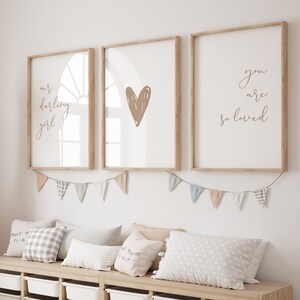 Nursery wall art set of 3 for a baby girl room with the nursery quote Our Darling Girl You Are So Loved