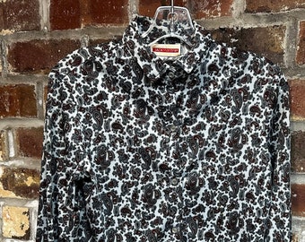 May include: A long-sleeved button-down shirt with a paisley print in shades of blue, black, and white.