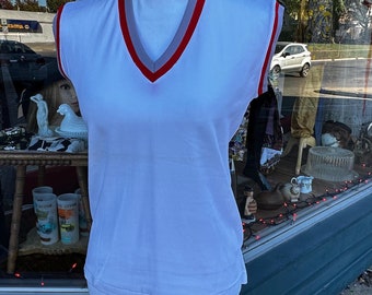 Può includere: Maglia bianca senza maniche con scollo a V rosso e grigio.
