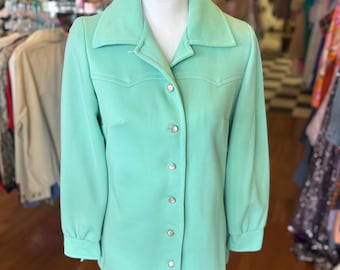 May include: A mint green long-sleeved button-up shirt with a collared neckline and a slightly flared hem.