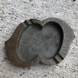 May include: A vintage brass ashtray shaped like a heart with musical notes and the words "The Sweetest Music" engraved on the rim.