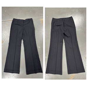 May include: A pair of black and white striped pants with a wide leg silhouette. The pants have a classic tailored look and are made from a lightweight fabric.