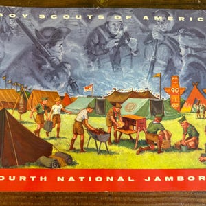 May include: Vintage Boy Scouts of America Fourth National Jamboree poster. The image features a painted scene of scouts camping, with tents, totem poles, and scouts in uniform. The top of the poster reads "Boy Scouts of America."