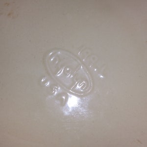 Peut inclure: Gros plan sur un plat en c&eacute;ramique blanche avec un logo ovale en relief qui dit "Royal" en &eacute;criture cursive.