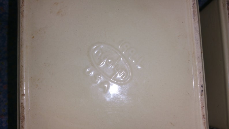 Peut inclure: Gros plan sur un plat en c&eacute;ramique blanche avec un logo ovale en relief qui dit "Royal" en &eacute;criture cursive.