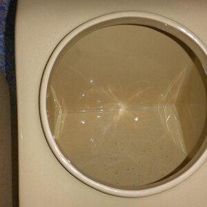 Peut inclure: Gros plan de l'int&eacute;rieur d'un pot en c&eacute;ramique de couleur cr&egrave;me avec une ouverture ronde. L'int&eacute;rieur du pot est vide et semble &ecirc;tre verni.