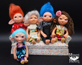 May include: Five handmade fantasy dolls with colorful hair and clothing sitting on a floral patterned couch. The dolls have large eyes and elf-like ears.