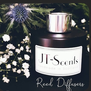 May include: A black glass bottle with a silver lid and a white label that reads "JT-Scents handmade in Scotland". The bottle is labelled "Reed Diffusers".