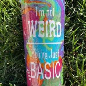 May include: A colorful, glittery tumbler with a white design that reads "I'm not weird, you're just basic".