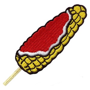 Pode incluir: Um remendo bordado de um cachorro de milho em um pau. O cachorro de milho é coberto com molho vermelho e é amarelo e vermelho.