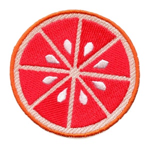 Könnte beinhalten: Ein gestickter Aufnäher mit einer Grapefruit-Scheibe, mit roten und orangen Nähten und weißen Kernen.