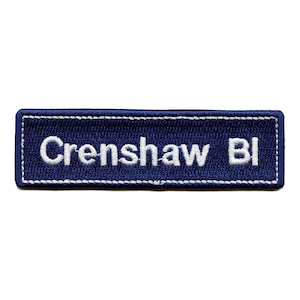 Może przedstawiać: Naszywka haftowana na niebiesko z białymi szwami, na której widnieje napis "Crenshaw Blvd."