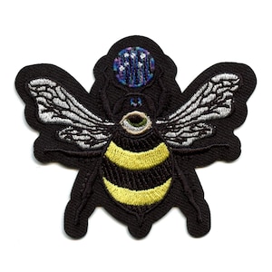 May include: Black embroidered patch of a bee with a single large eye, yellow and black striped abdomen, and a purple and blue patterned crown.