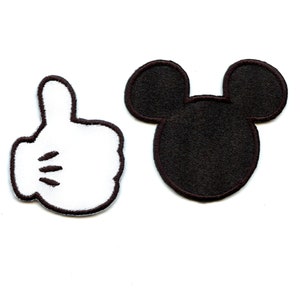 Könnte beinhalten: Zwei Bügelbilder, eines mit einer weißen Mickey Mouse Hand, die einen Daumen hoch zeigt, und das andere mit einem schwarzen Mickey Mouse Kopf.