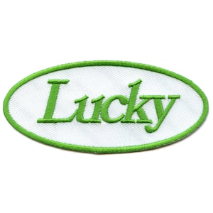 Op de afbeelding: Groen geborduurd ovaal patch met het woord "Lucky" in witte letters.