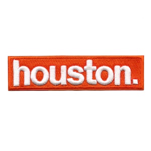 May include: Orange rectangular patch with white embroidered text that reads "houston."
