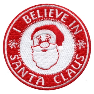 Peut inclure: Patch brodé rouge et blanc avec un visage de Père Noël blanc et le texte "I Believe in Santa Claus".