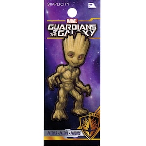 May include: Iron-on patch featuring a cartoon image of Groot from Guardians of the Galaxy. The patch is brown and green and has a purple and black background. The text "MARVEL GUARDIANS OF THE GALAXY" is at the top of the patch.