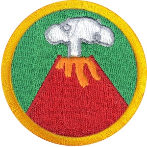 May include: A green and yellow embroidered patch with a red volcano erupting with orange lava and a white smoke cloud.