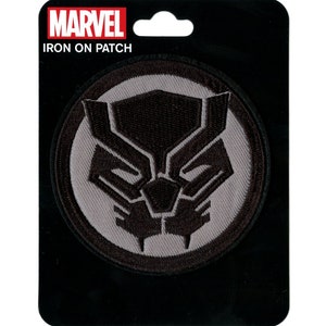 Può includere: Toppa termoadesiva nera e grigia con il logo di Black Panther. Il logo è una testa di pantera nera stilizzata all'interno di un cerchio grigio. La toppa ha il testo "MARVEL IRON ON PATCH" in alto.