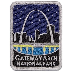 May include: A gray and silver embroidered patch with a blue background depicting the Gateway Arch in St. Louis, Missouri. The text "Gateway Arch National Park" is printed in white below the arch.