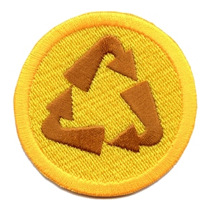 Könnte beinhalten: Ein gelber runder Patch mit einem braunen gestickten Recycling-Symbol.