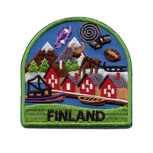 May include: An embroidered patch with a blue background featuring a winter scene with red houses, a reindeer, and a sled. The text "FINLAND" is embroidered in black on a green background.