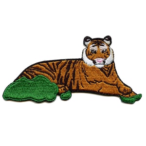 May include: An embroidered iron-on patch featuring a brown and orange tiger lying on a green patch of grass.