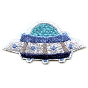 May include: An iron-on patch embroidered with a cartoon UFO in white, blue and grey. The UFO has a light blue dome and a dark blue base.